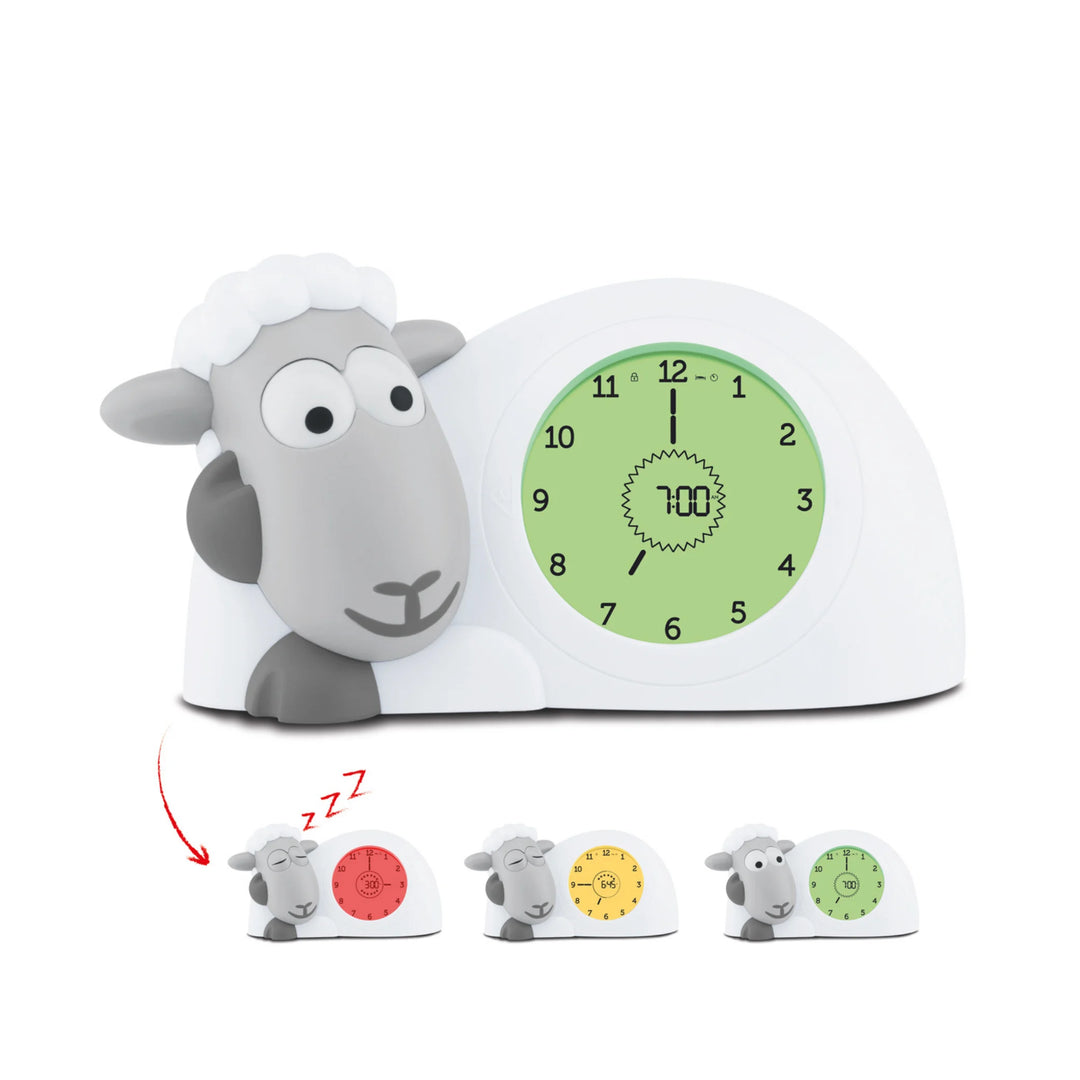 ZAZU Sam the Sheep sleep trainer clock for children, showing green wake-up mode on the main display with additional red, yellow, and green sleep training light options illustrated below.