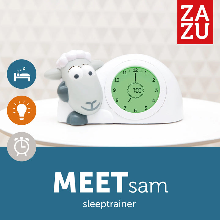 ZAZU Sam the Sheep sleep trainer clock in green wake-up mode displayed with bedtime, nightlight, and timer icons, featuring the ZAZU branding and ‘Meet Sam’ sleeptrainer introduction on a white and blue background.