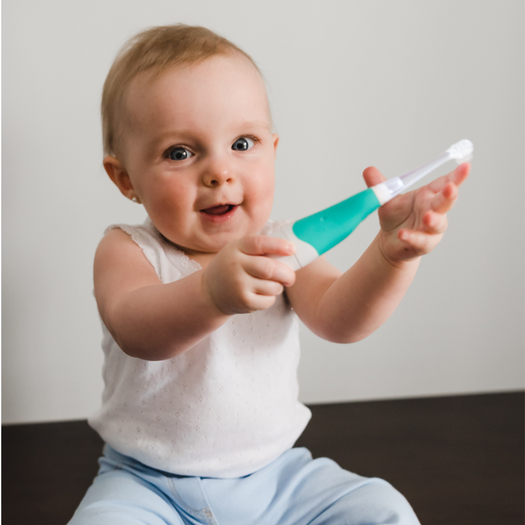 BBLuv Sonik Electric toothbrush being held by a happy baby