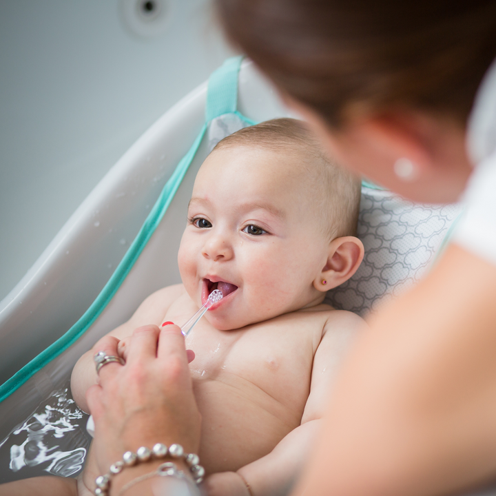 BBLuv Sonik electric toothbrush being used by a mother on her infant in the bath