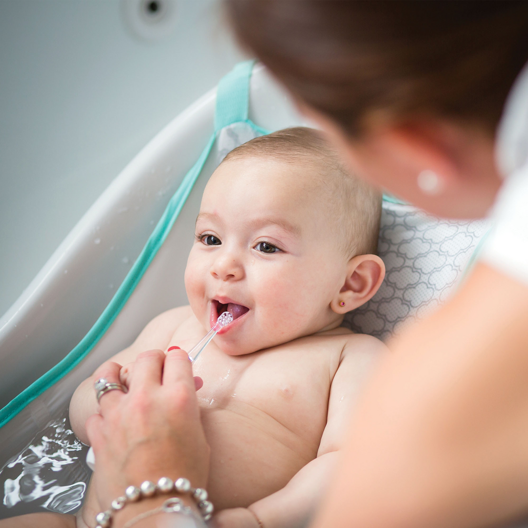 BBLuv Sonik Electric toothbrush being used by a mother to brush her baby's teeth in the bath