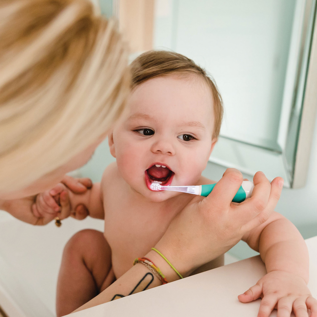 BBLuv Sonik electric toothbrush being used by a mother to brush her toddlers teeth