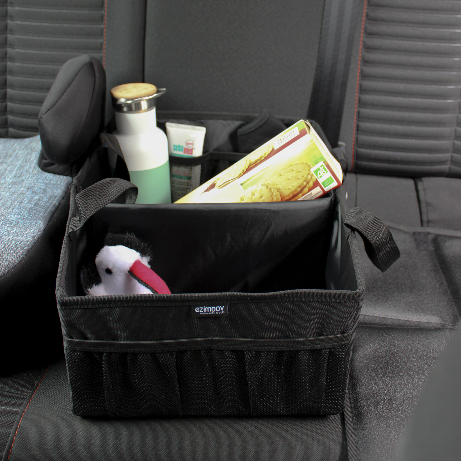 This image is a close up of the caddy holding biscuits, a small teddy and a water bottle.