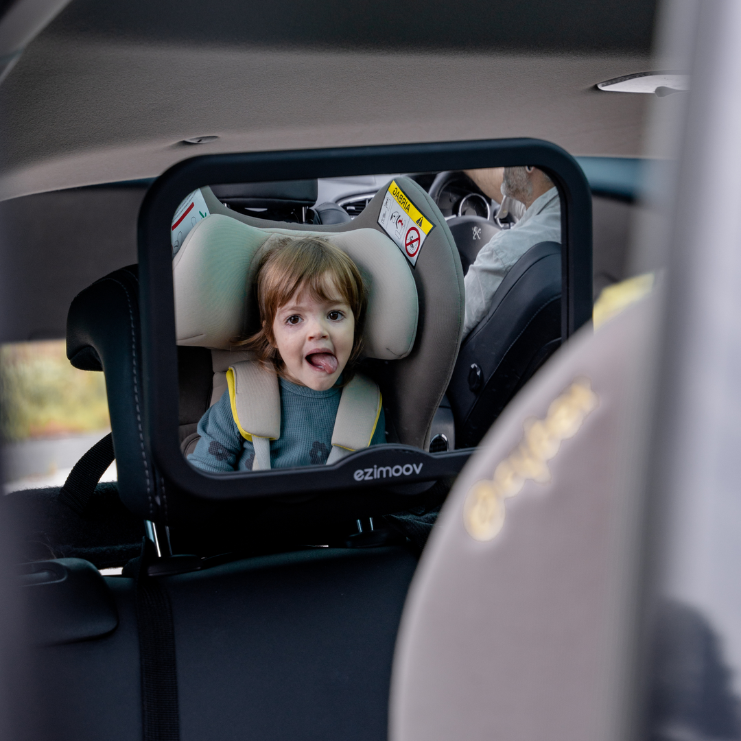 This image shows the large car seat mirror attached to the headrest of a back seat, with a child in the car seat.