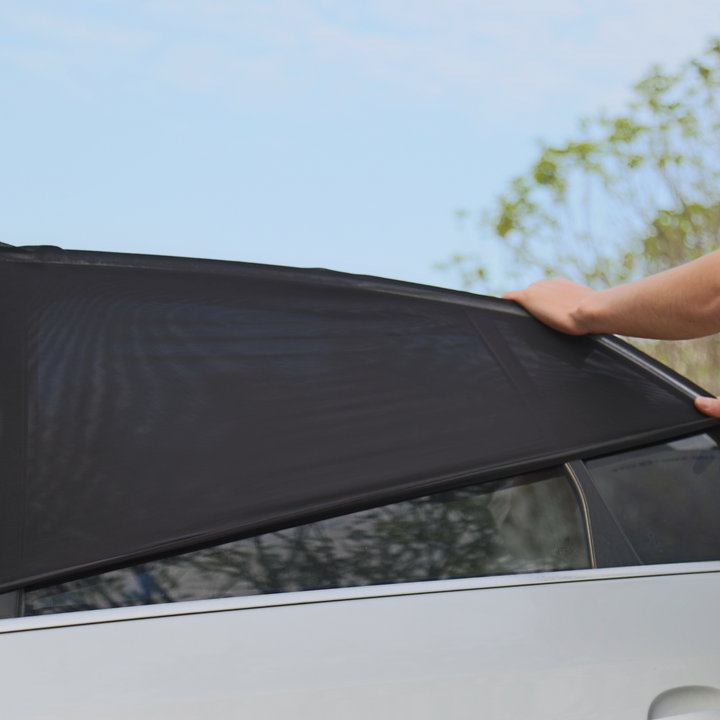 This image shows a parent installing the Ezimoov Car Window Sun Shade Socks on their car window.