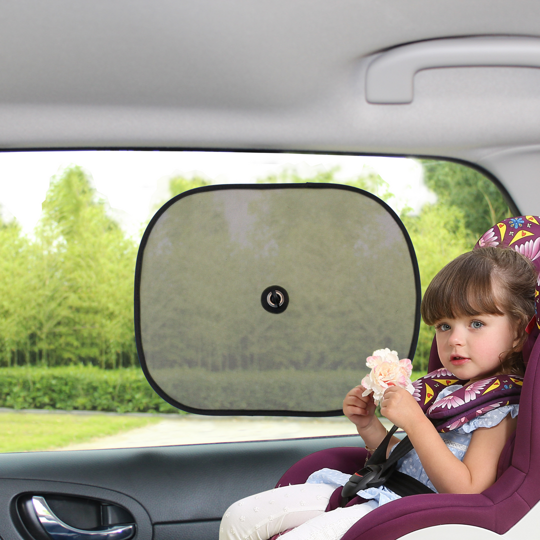 This image shows a toddler holding a flower sitting in their car seat with the Ezimoov sun stopper on the window beside them.