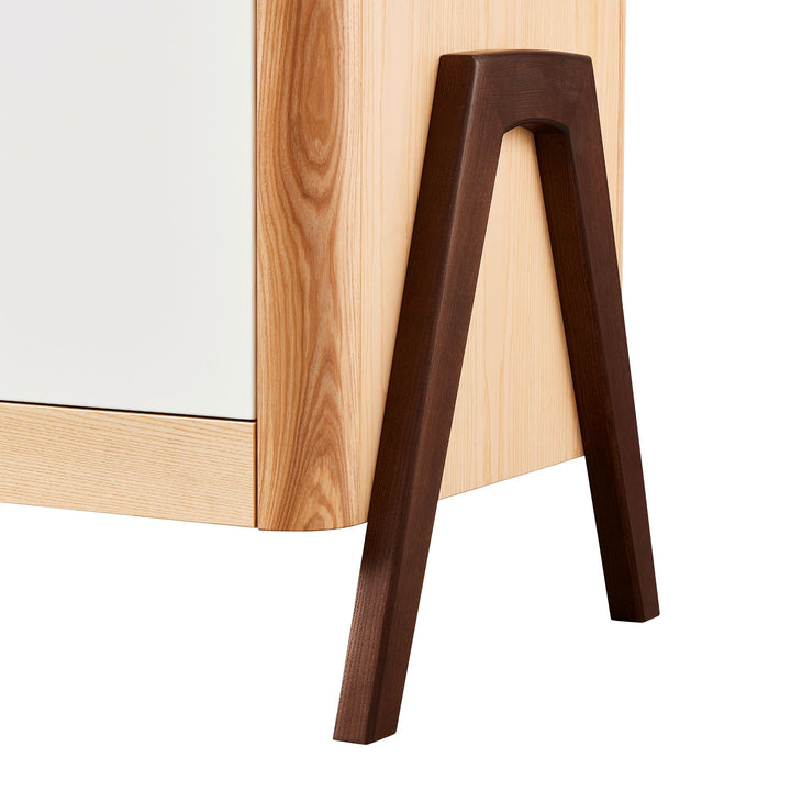 Close up of the Walnut legs of the Gaia Baby Hera Dresser in Natural Ash and Walnut