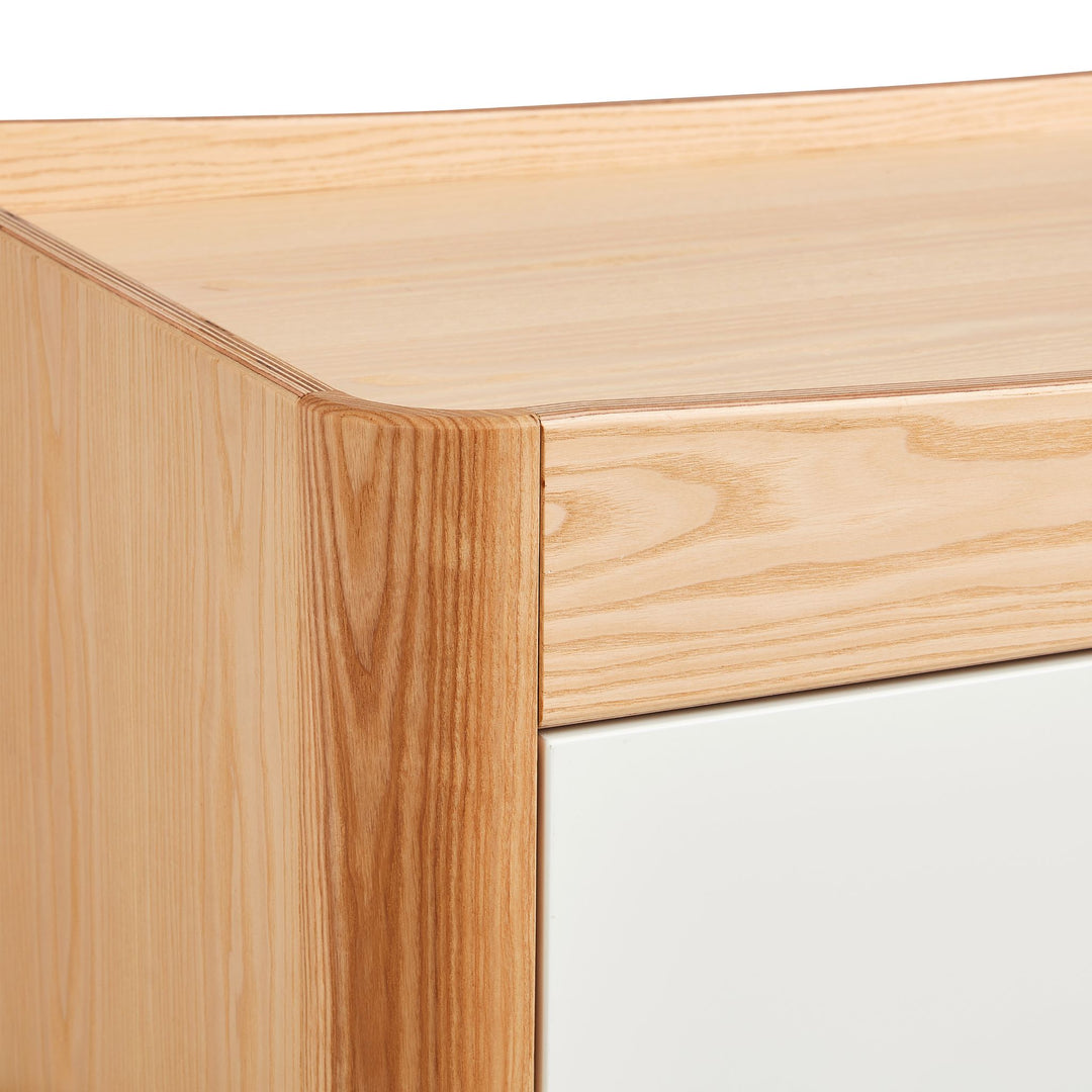closeup of Gaia Baby Hera Dresser in Natural Ash and Walnut top showing the natural wood grain and elevated rim