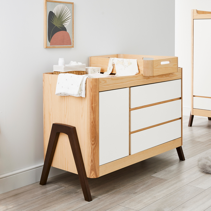 lifestyle image of Gaia Baby Hera Dresser and Hera Changing Station in Natural Ash and Walnut
